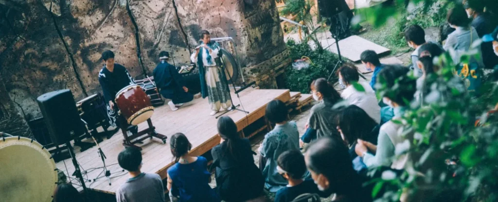 An outdoor live performance of Japanese musical instruments held in the forest