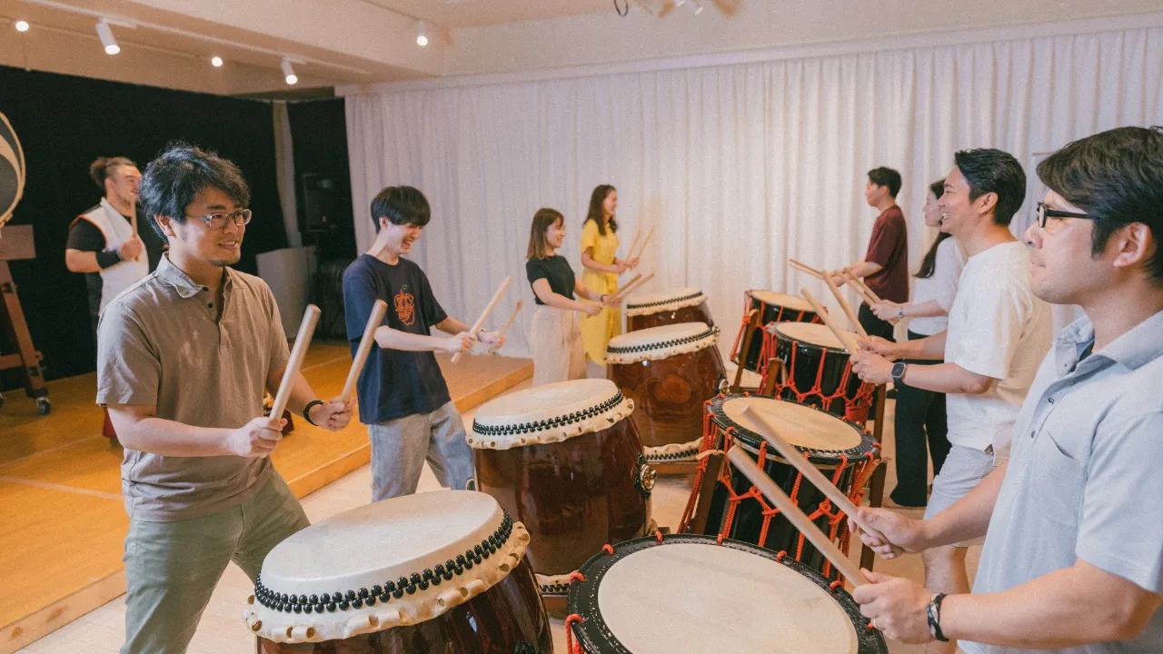 Everyone enjoying a team-building workshop with Japanese drums