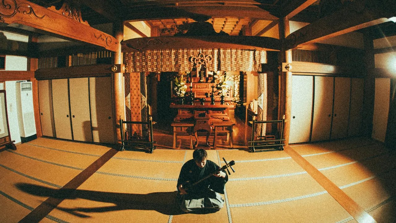 A shamisen player performing at a temple