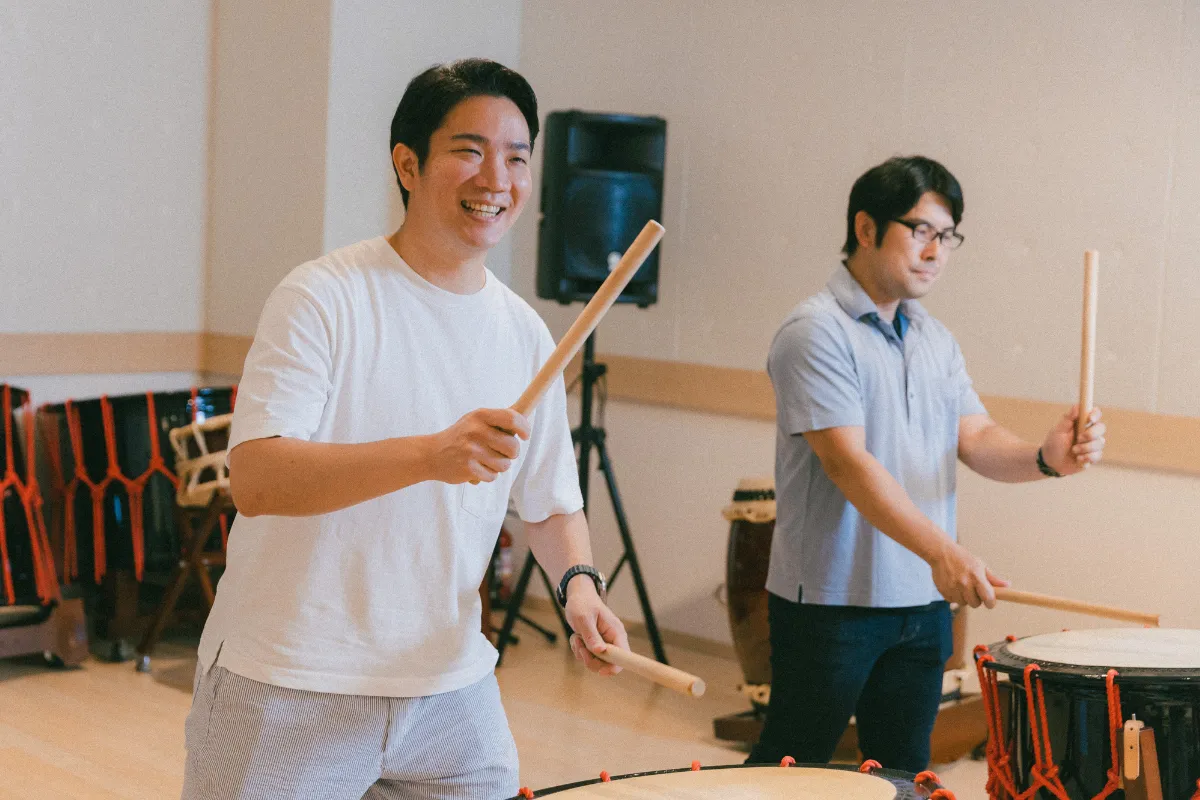 Team members and clients bonding through a collaborative taiko drumming workshop experience