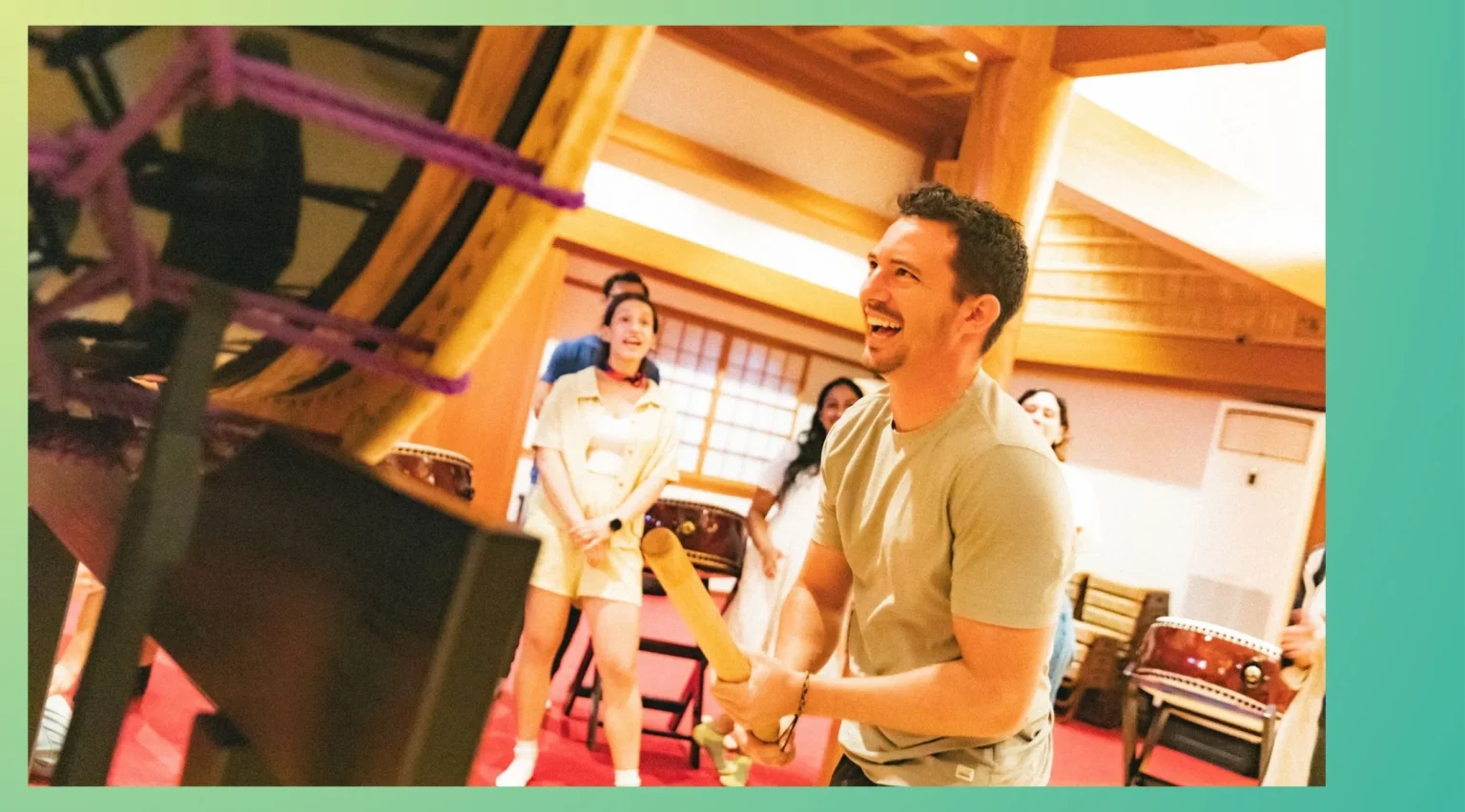 Smiling employees enjoying a taiko drum team building event in Tokyo, participating in an engaging corporate team building activity