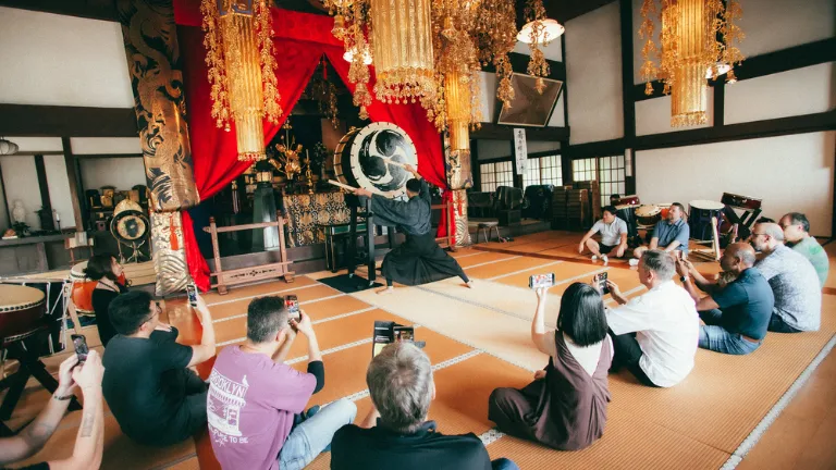 Participants immersed in a professional taiko performance